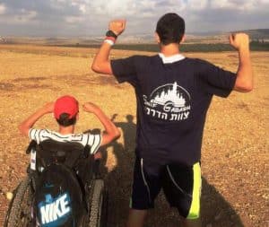 מתנדב מטייל עם תייר נכה בטבע